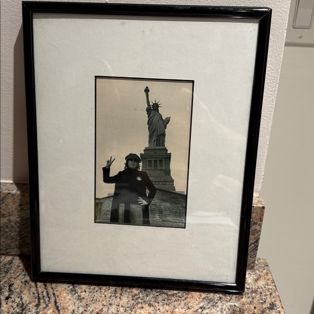 John Lennon giving the peace sign at Statue of Liberty New York. Beatles.